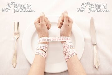 人,设备用品,桌子,餐具,社会问题_560110967_Woman in front of empty plate bound with tape measure_创意图片_Getty Images China 人,设备用品,桌子,餐具,社会问题_560110967_Woman in front of empty plate bound with tape measure_创意图片_Getty Images China