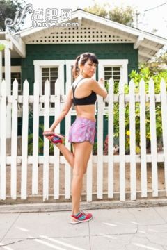 人,短裤,建筑,生活方式,运动_486459235_Young woman stretching leg by picket fence_创意图片_Getty Images China 人,短裤,建筑,生活方式,运动_486459235_Young woman stretching leg by picket fence_创意图片_Getty Images China
