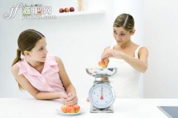 人,衣服,家具,食品,生活方式_81984181_Mother and daughter weighing apples on scale, looking at each other_创意图片_Getty Images China 人,衣服,家具,食品,生活方式_81984181_Mother and daughter weighing apples on scale, looking at each other_创意图片_Getty Images China