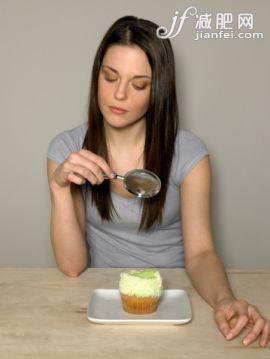 桌子,T恤,甜食,饮食,影棚拍摄_75402564_Young woman looking at cake with magnifying glass_创意图片_Getty Images China