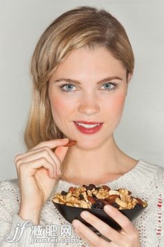 人,饮食,休闲装,生活方式,影棚拍摄_557133567_Portrait of a beautiful woman eating dried fruit_创意图片_Getty Images China 人,饮食,休闲装,生活方式,影棚拍摄_557133567_Portrait of a beautiful woman eating dried fruit_创意图片_Getty Images China