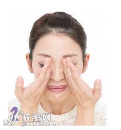 2.用两手小指的一侧放到脸颊骨上。