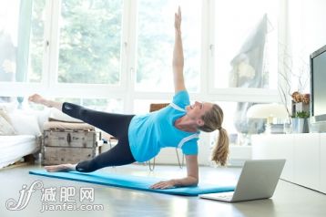人,住宅内部,沟通,生活方式,技术_556670909_Woman with laptop exercising on gym mat in living room_创意图片_Getty Images China 人,住宅内部,沟通,生活方式,技术_556670909_Woman with laptop exercising on gym mat in living room_创意图片_Getty Images China